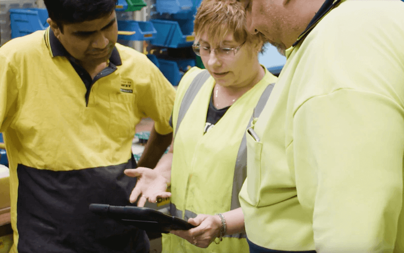 Team Members Using Tablet for Continuous Improvement